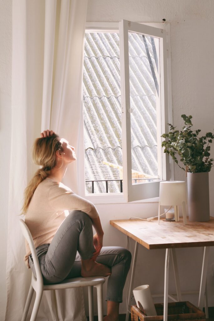 Why time feels faster as you get older, illustrated by a person reflecting beside a sunlit window
