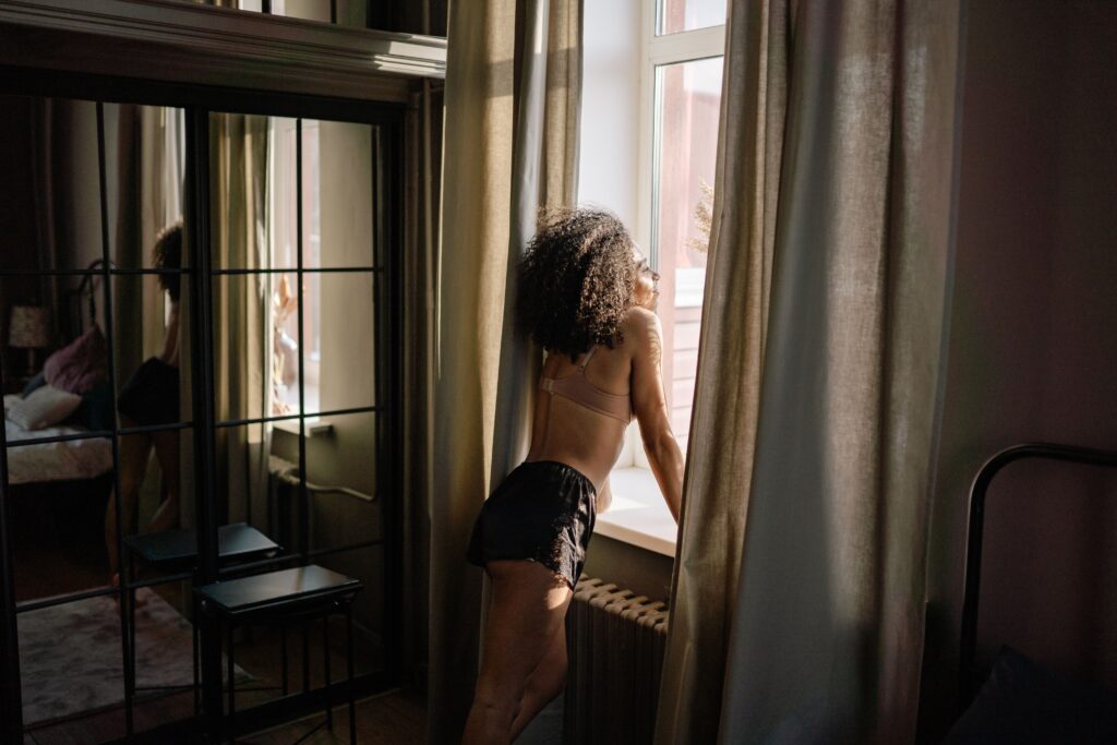 Person looking through a window while reflecting on how to find yourself again